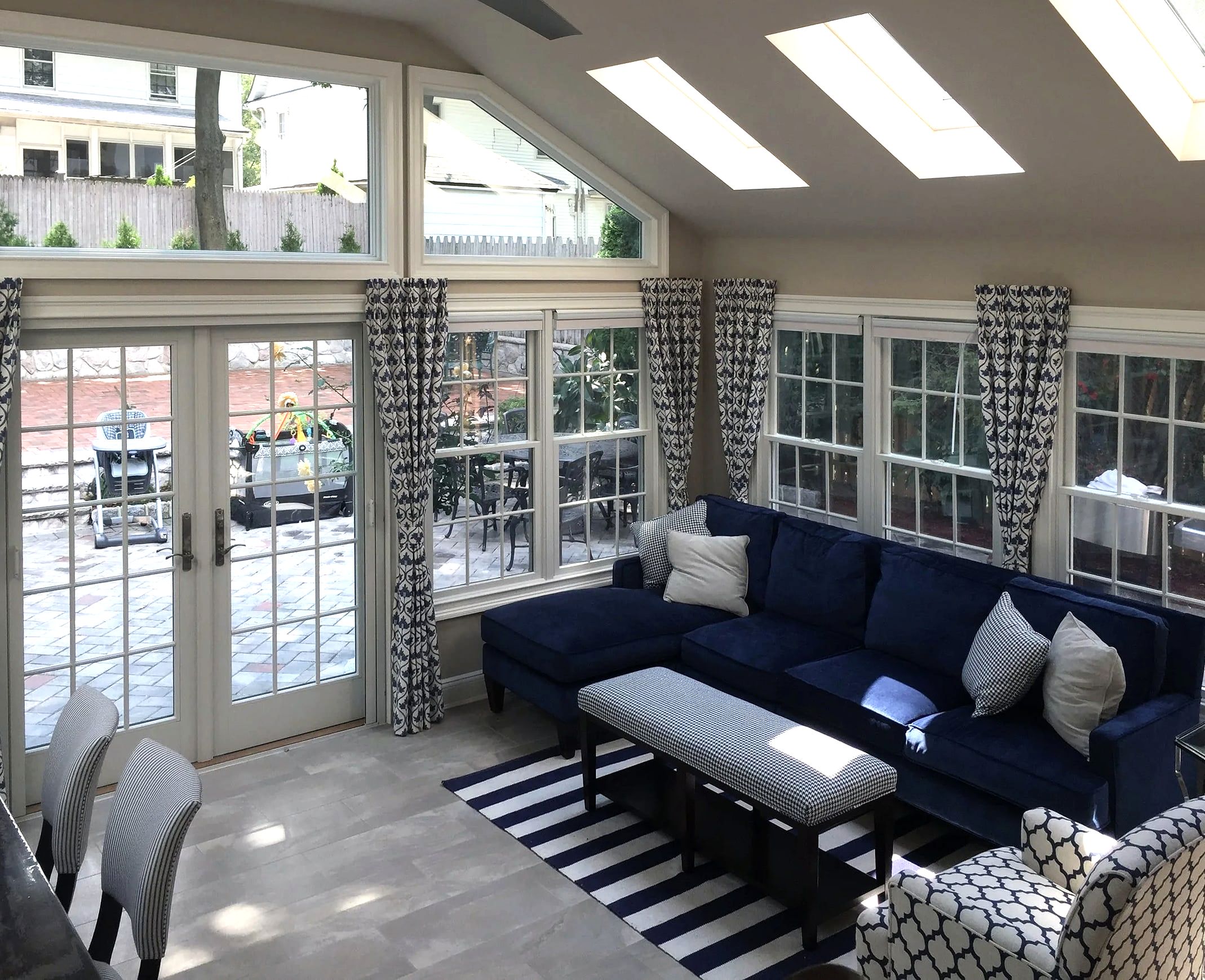 Sunroom addition with skylights, blue sofa, French doors to patio